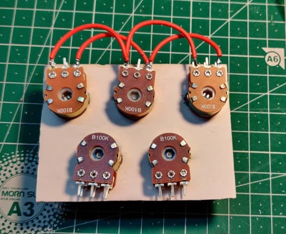 Five 100K potentiometers mounted on a foam-board panel, supply rails daisy-chained in red wire